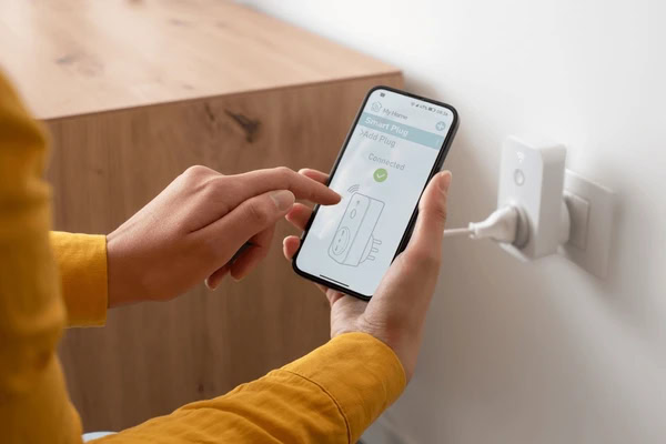 Person setting up smart plug using mobile app
