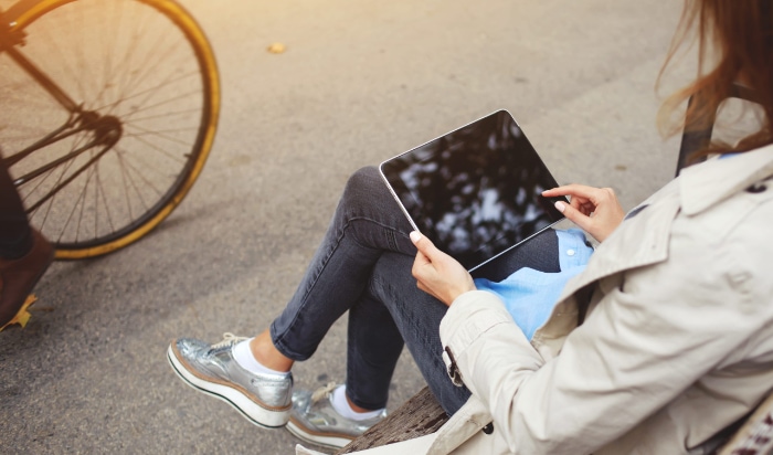 Person sitting on a bench using an iPad