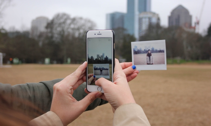 Person taking picture of polaroid photo