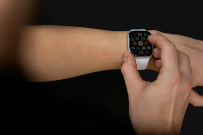 Person tapping Apple Watch app grid on wrist