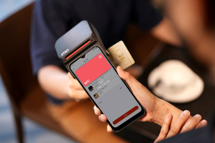 Person tapping a credit card for contactless payment