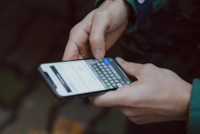 Person texting on a smartphone outdoors