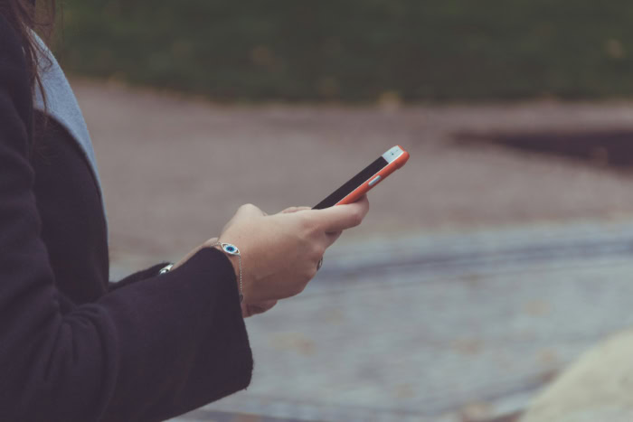 Person texting on smartphone outdoors
