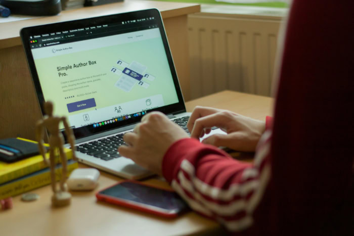 Person typing on a laptop showing a website