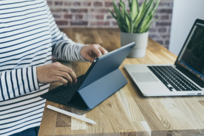Person typing on a tablet with keyboard accessory