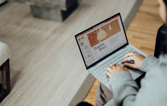 Person typing on laptop displaying Positive Space presentation