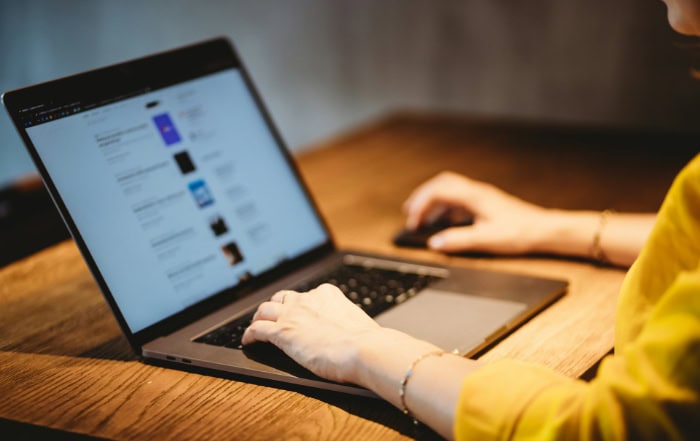 Person typing on laptop displaying web browser interface