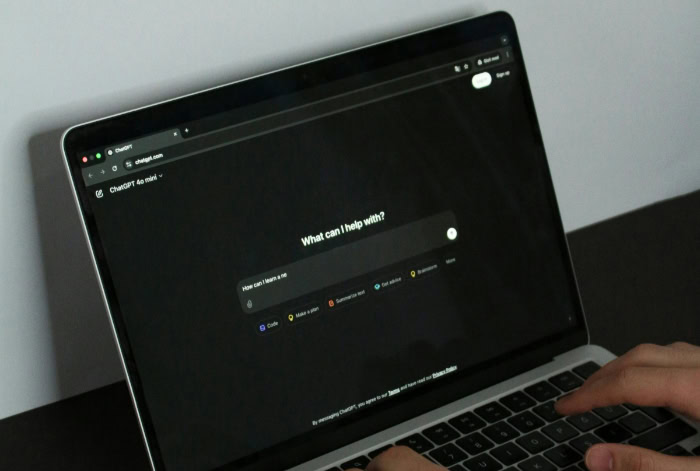 Person using ChatGPT on a laptop with dark mode