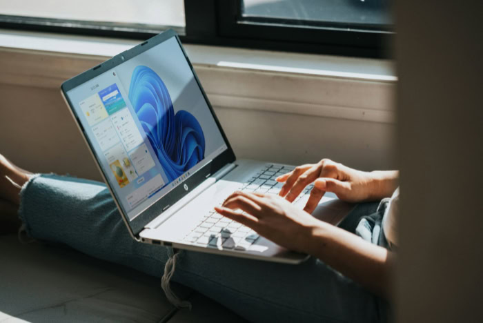 Person using Windows laptop near a bright window