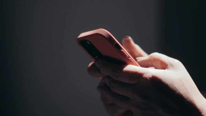 Person using a smartphone in dim lighting