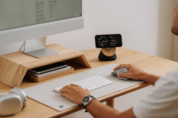 Person using a wireless mouse at a desk setup