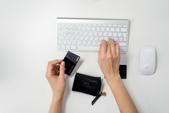 Person using credit card and keyboard for online shopping