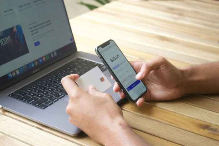 Person using debit card and smartphone for payment