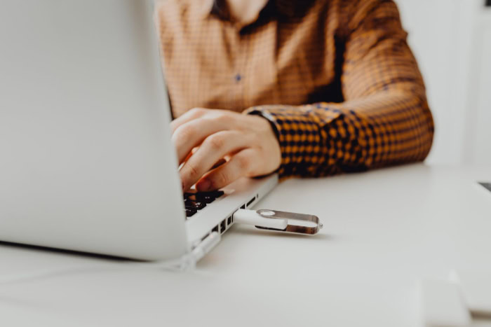 Person using laptop with USB flash drive inserted