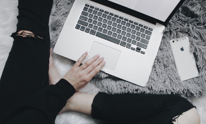 Person using macbook on carpet