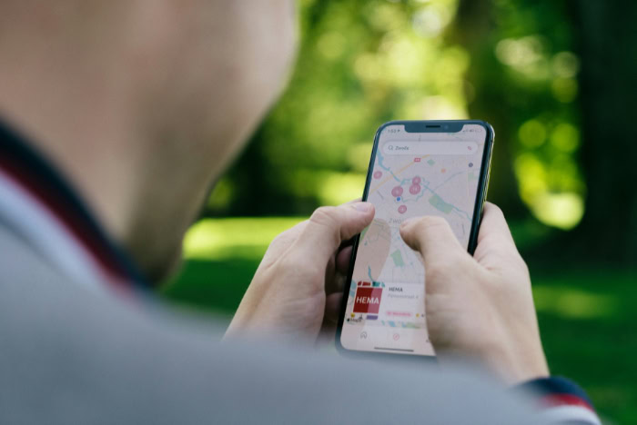 Person using smartphone with map app outdoors