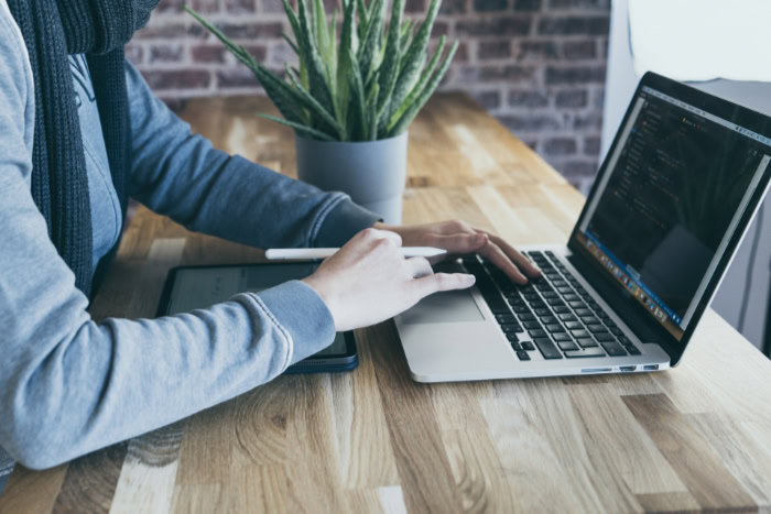 Person using trackpad on laptop and digital pen