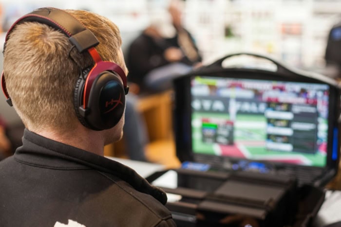 Person wearing gaming headphones while watching on a monitor