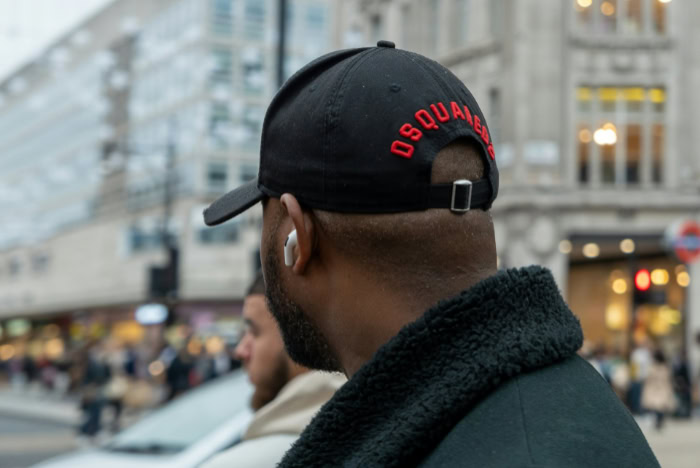 Person wearing wireless earbuds outdoors in city