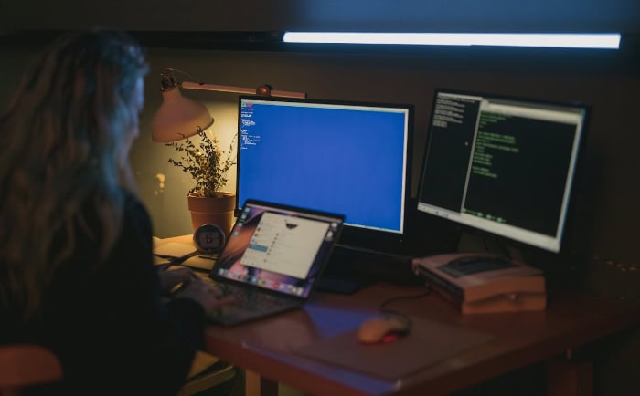 Person working at desk with multiple monitors