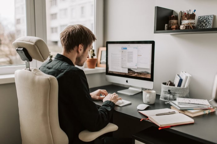 Person working on a desktop computer at home office