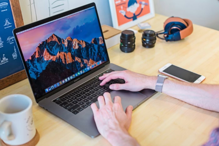 Person working on a laptop at a wooden desk