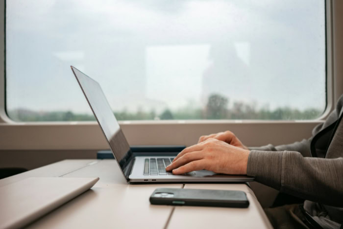 Person working on a laptop while traveling by train