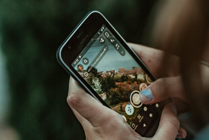 Persons hands holding phone using Snapchat camera