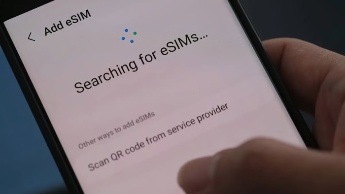 Phone screen showing Searching for eSIMs interface