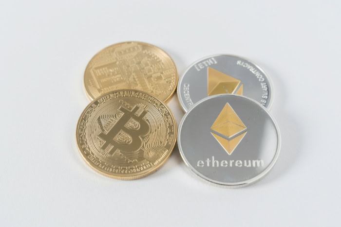 Physical Bitcoin and Ethereum coins on white background