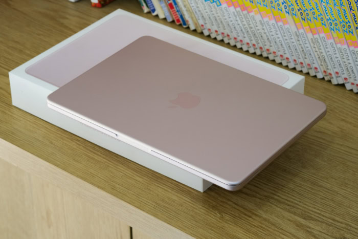 Pink MacBook Neo sitting on white