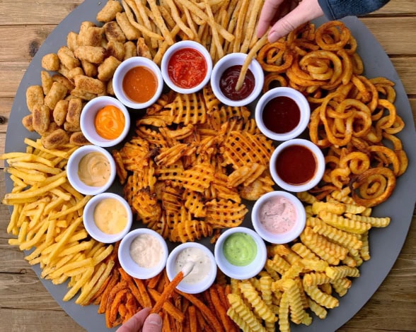 Platter of various fried foods with assorted dipping sauces rotated