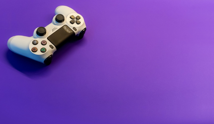 White playstation controller on purple background