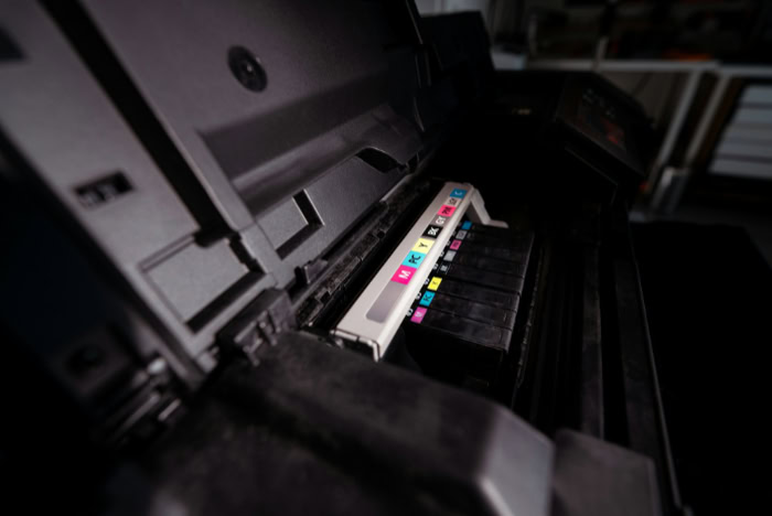 Printer ink cartridges installed showing CMYK color labels