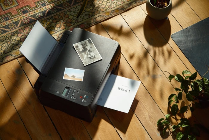 Printer with photos and documents on floor