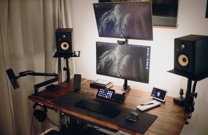 Professional dual monitor desktop setup with speakers and microphone