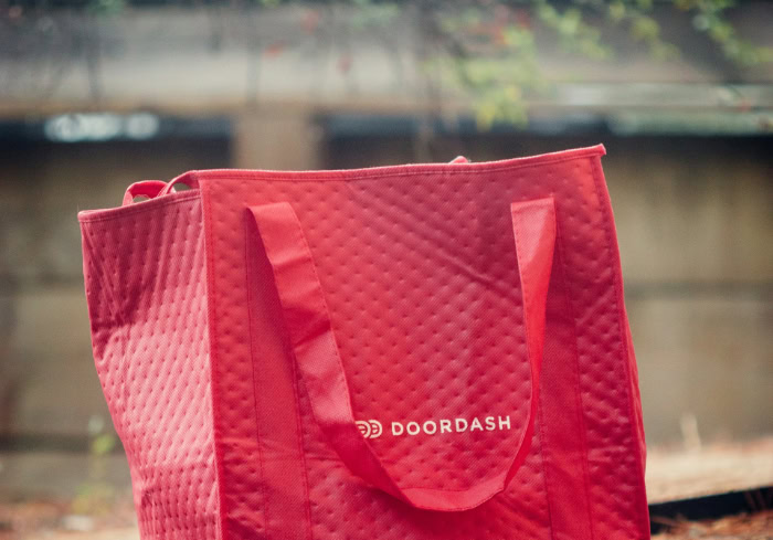Red DoorDash insulated food delivery bag on ground