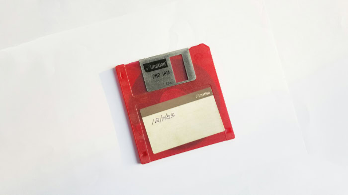 Red Imation 3.5 inch floppy disk with handwritten date