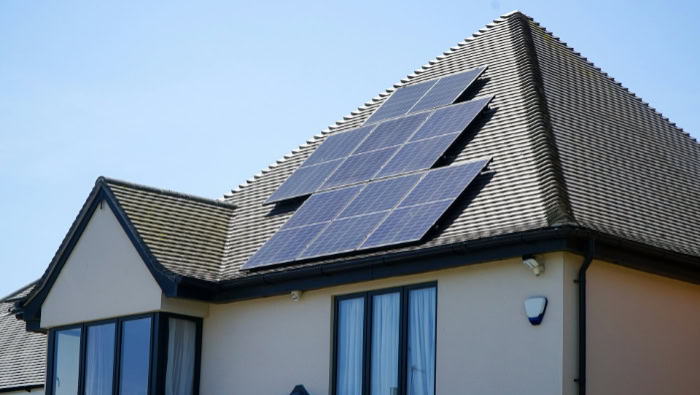 Residential house with solar panels on tiled roof