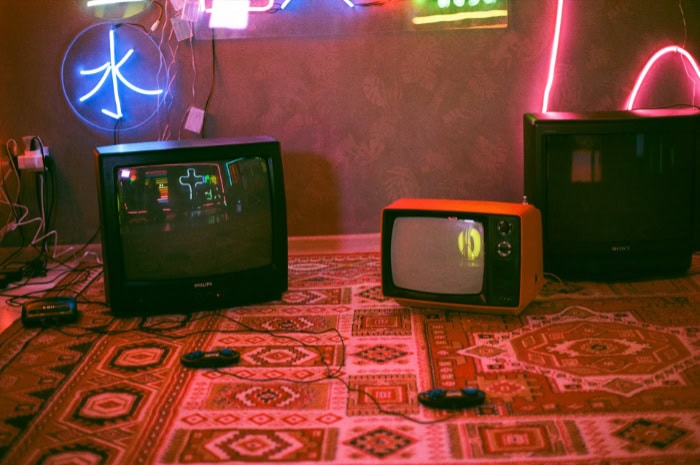 Retro gaming setup with vintage TVs on patterned carpet