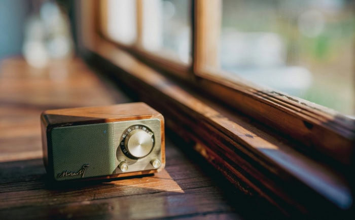 Retro wooden radio with tuning knob on table