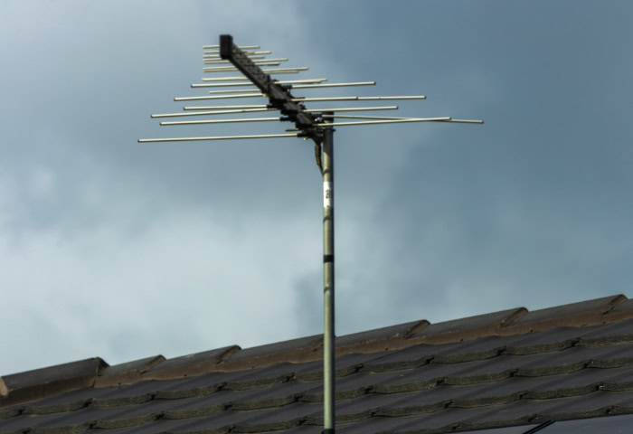 Rooftop TV antenna mounted above solar panels