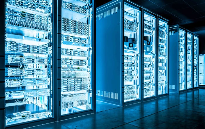 Rows of server racks in blue lit data center