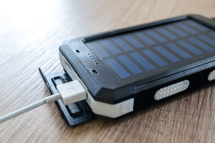 Rugged solar power bank with USB cable plugged in