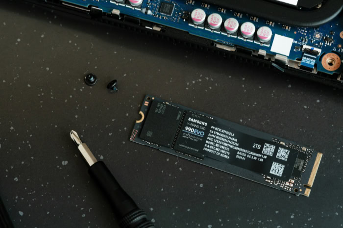 Samsung NVMe SSD with tools on a black surface