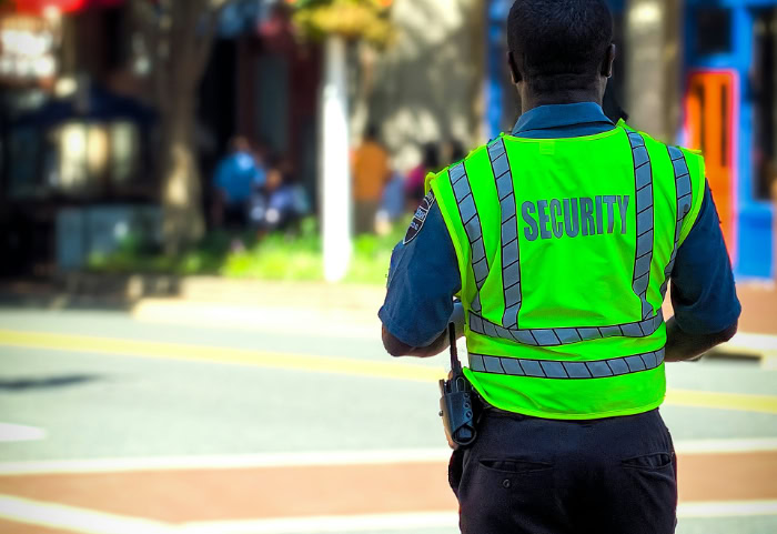 Security guard wearing neon green high visibility vest outdoors