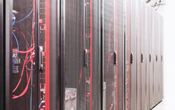 Server racks with mesh doors and visible red and blue cables