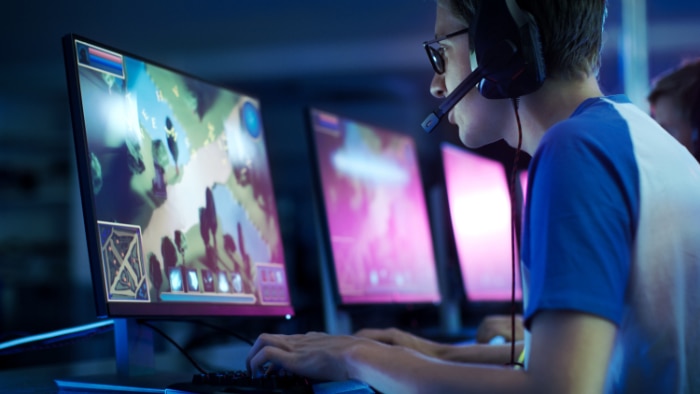 Side view of a gamer with a headset communicating with teammates