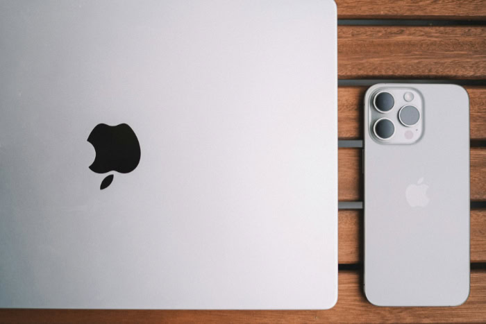 Silver Apple MacBook and iPhone Pro on wood