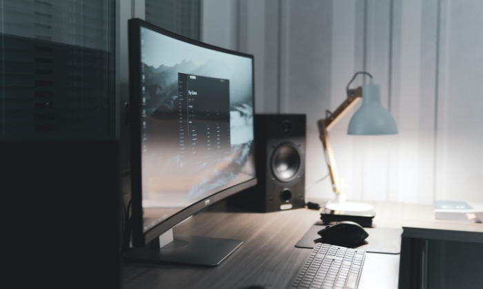 Sleek desk with ultrawide monitor and speaker